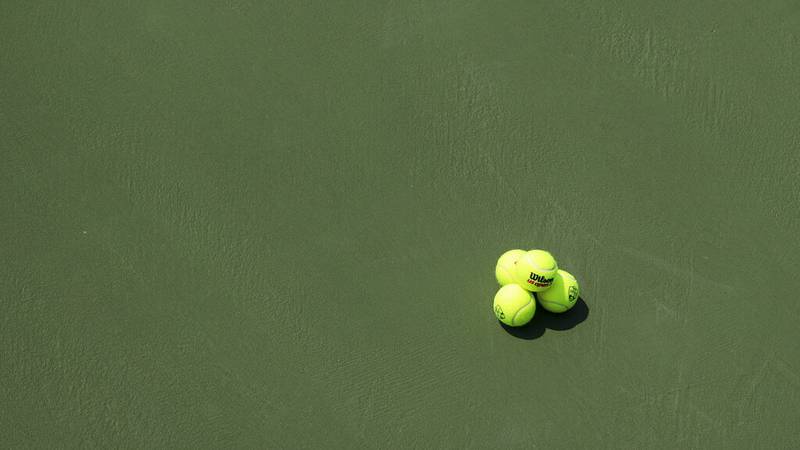 Tennis balls are stacked on the court during the men's double final of the Western & Southern...